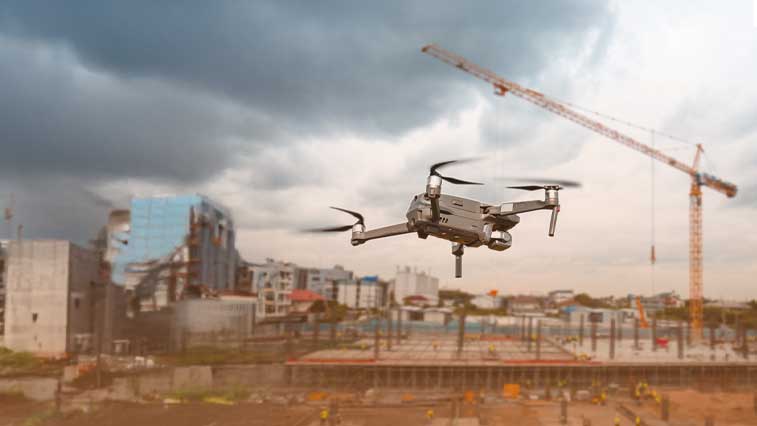 A bicycle share next to a street, with pedestrians and double-decker buses in the distance 