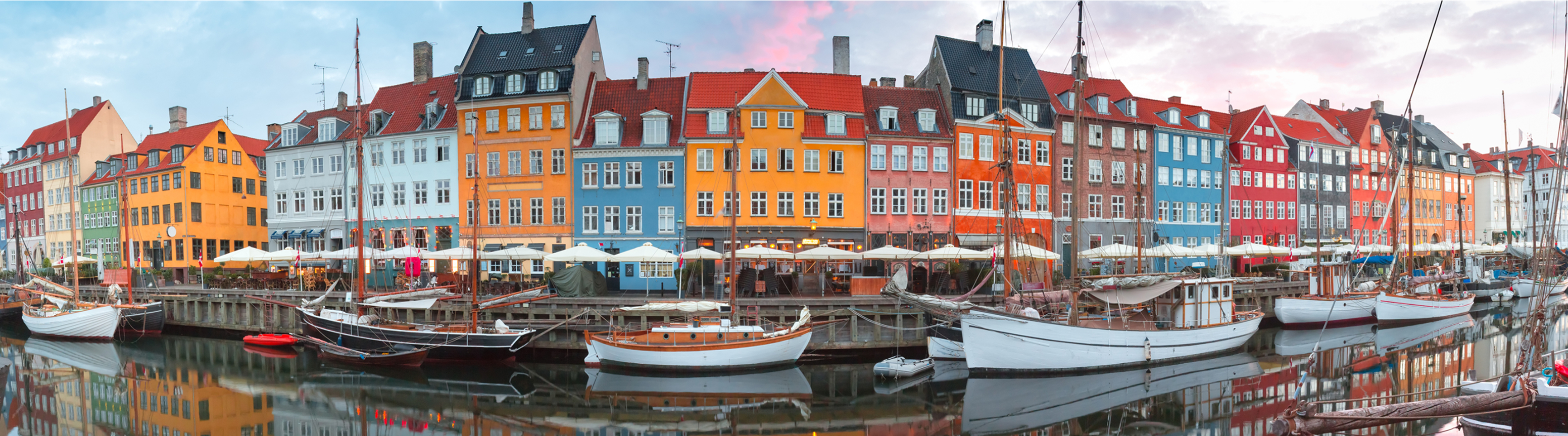 Boats anchored in a canal in front of colorful buildings in Copenhagen