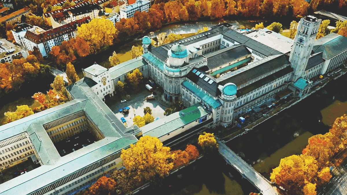 Image hors nadir d’un grand bâtiment administratif entouré d’arbres aux feuilles de couleur jaune et orange