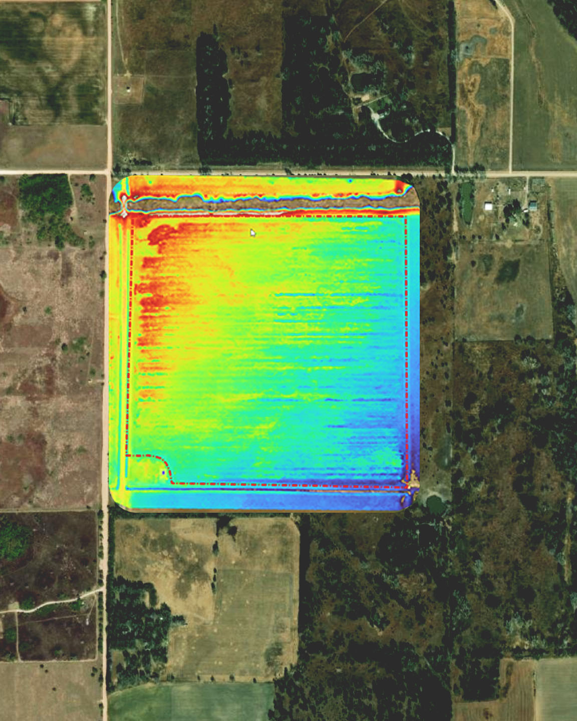 Off-nadir aerial imagery of a road cutting through a green and yellow patchwork of farm fields