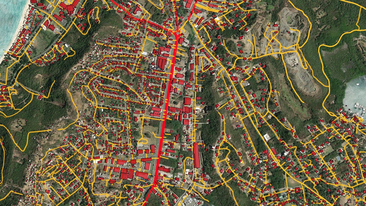Ein auf ein Satellitenbild von Grenada angewandter Arbeitsablauf zur Merkmalsextraktion zeigt Straßen in rot und gelb und Gebäude in rot