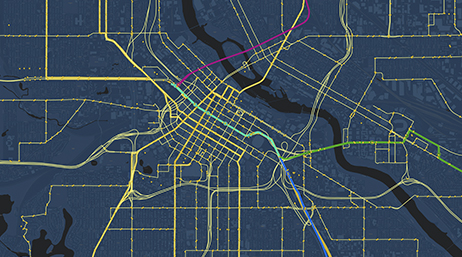 Dunkelgraue Karte, auf der Straßen in Gelb und Verkehrslinien in Rosa, Grün und Blau dargestellt sind